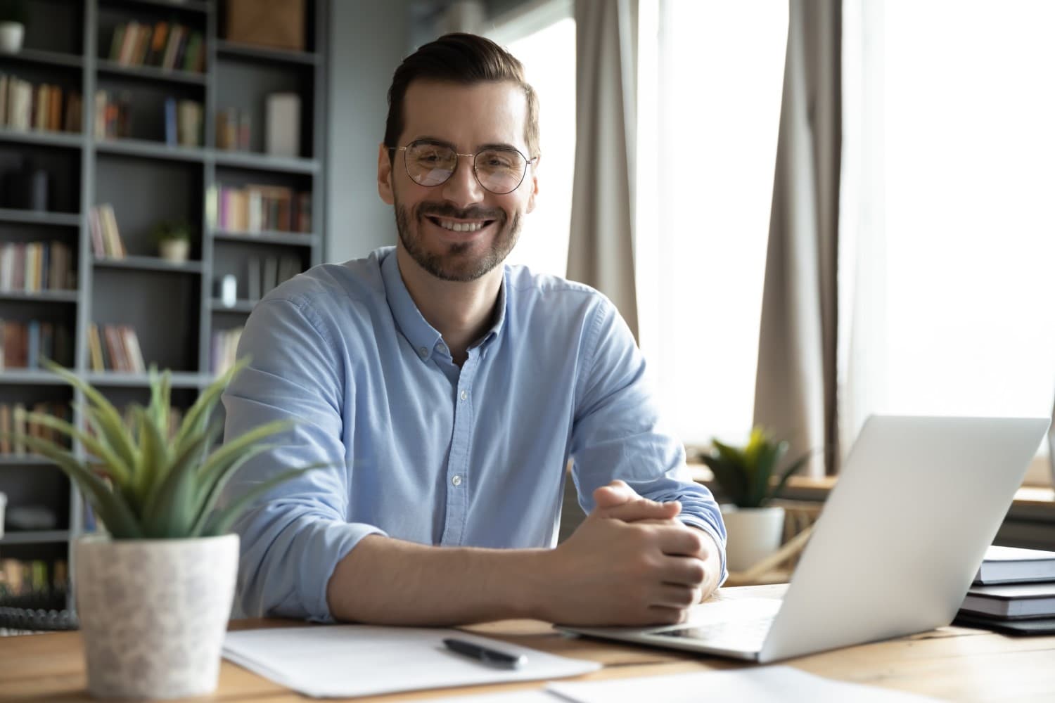 Smiling man with beard in front of laptop