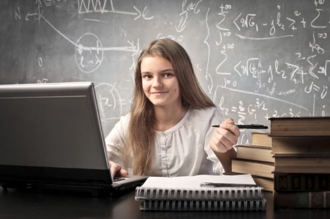 Math photo Smiling student in front of chalkboard